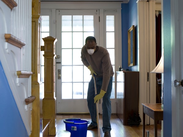 Operator running a floor-scrubbing machine in a public hall