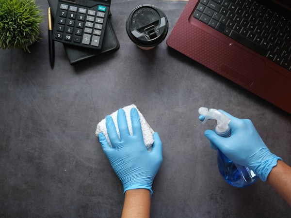 Janitorial staff disinfecting an office workspace