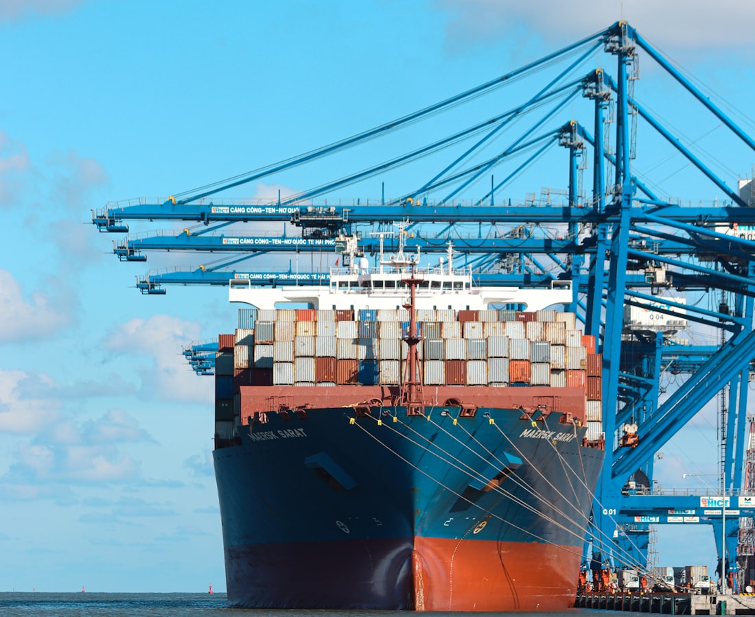 Container vessel berthed under ship-to-shore cranes at a West African port