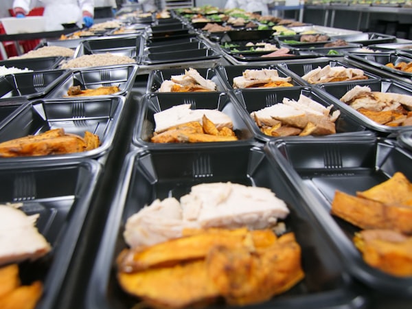 Industrial catering team plating meals in a commercial kitchen